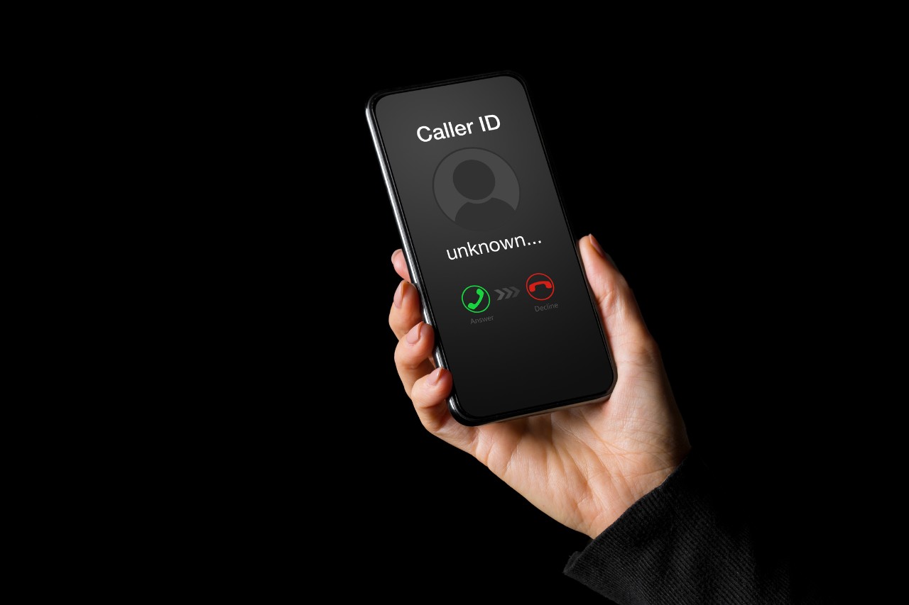 Person receiving call on phone from an unknown caller, isolated on black background