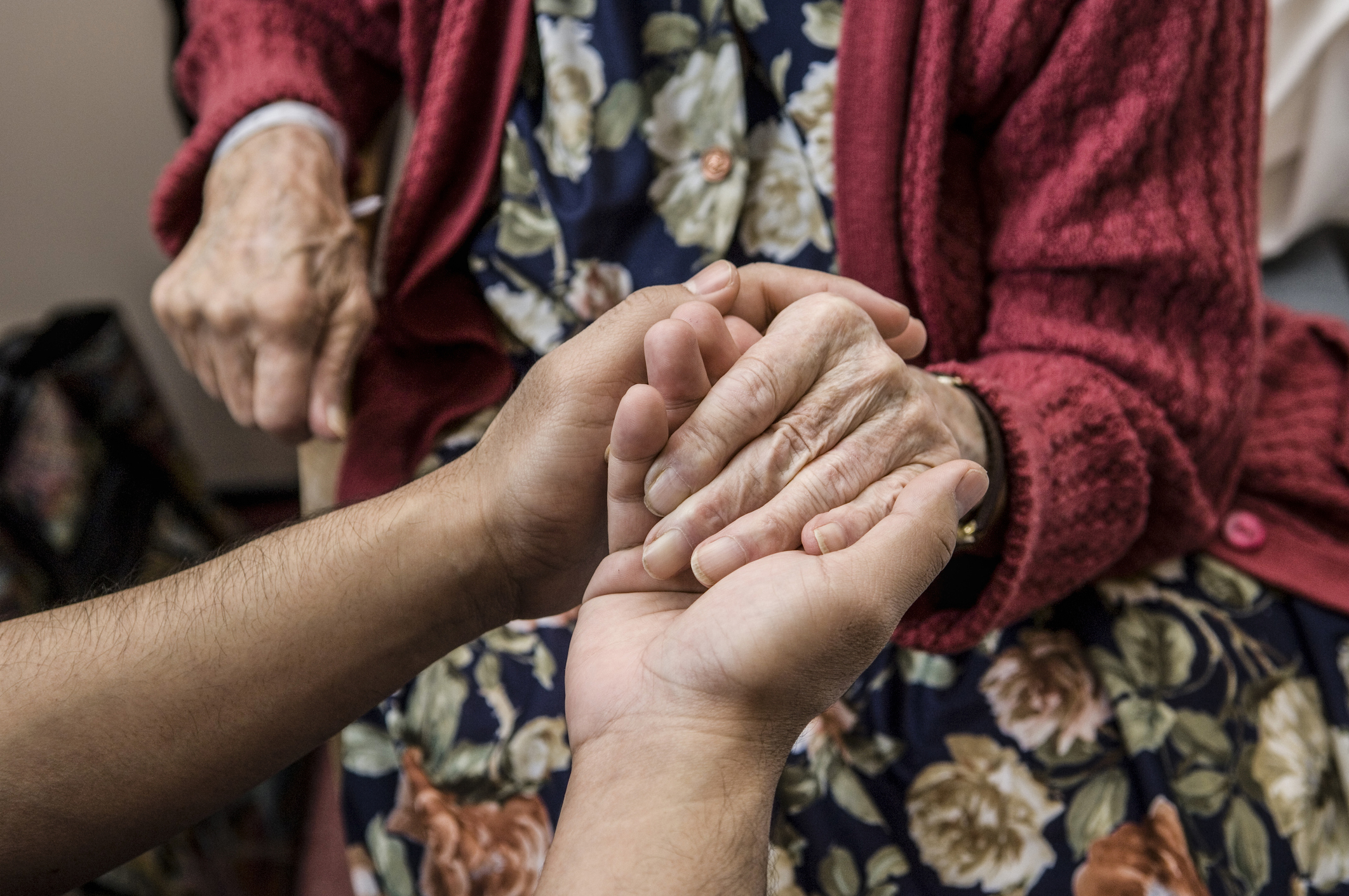 Nurse holding hands with elderly patient.