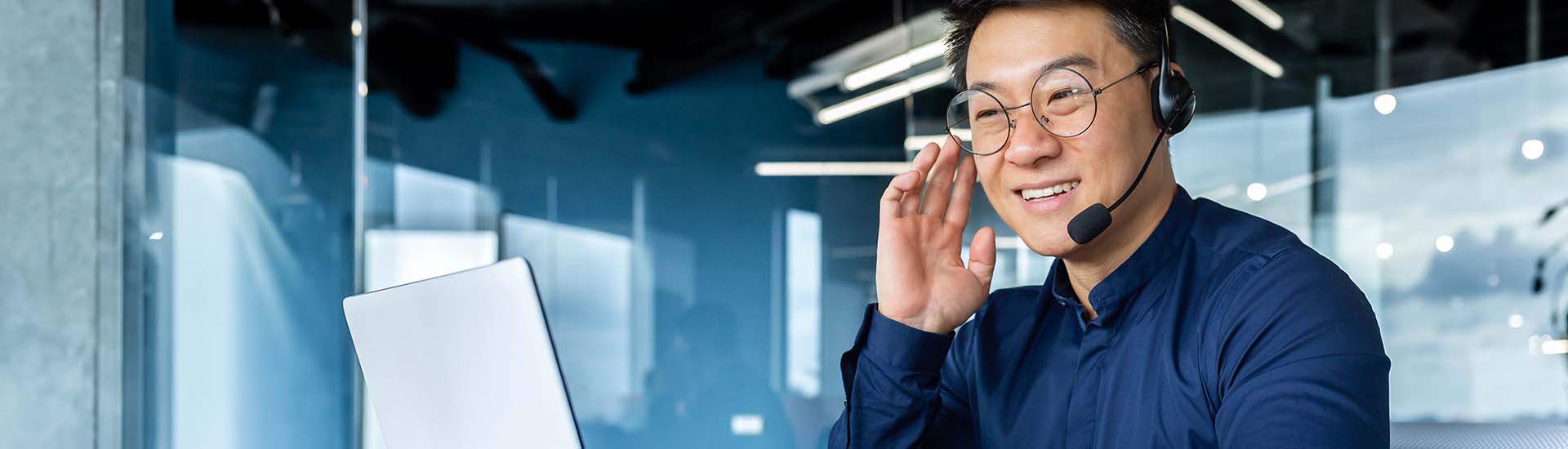 smiling telemarketer on computer with a headset