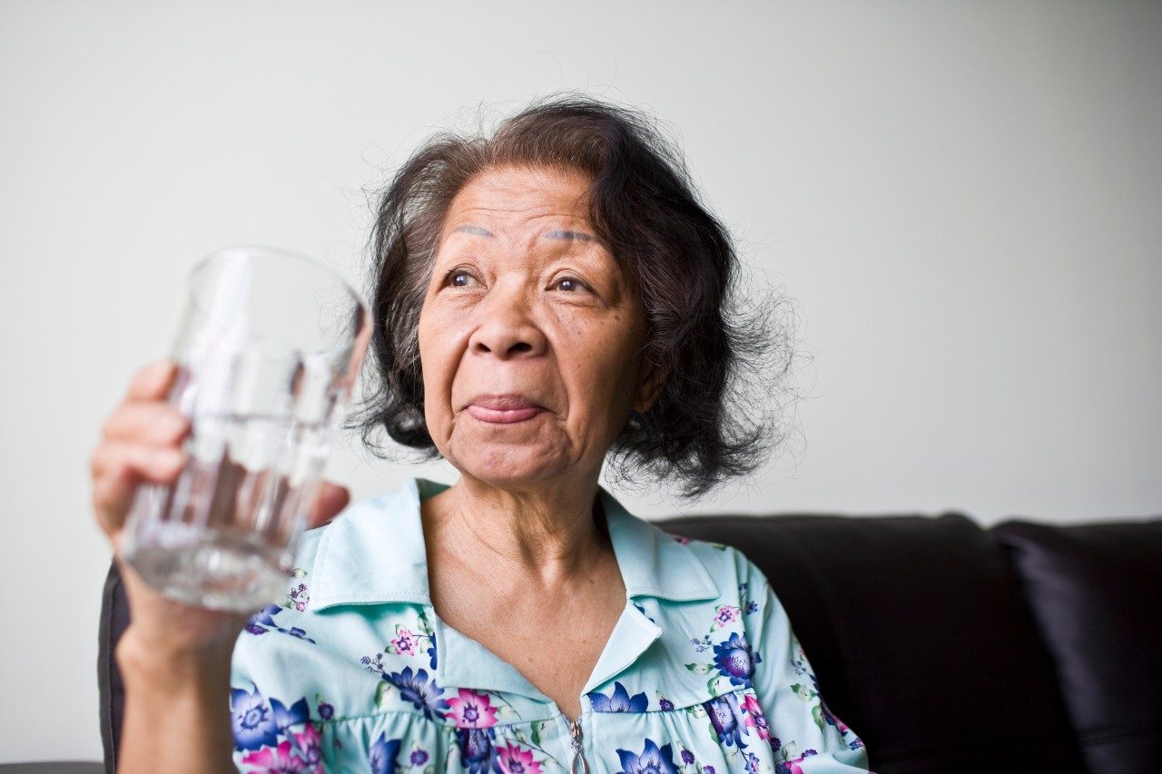 Mature Adult Asian Woman with a glass of refreshing water