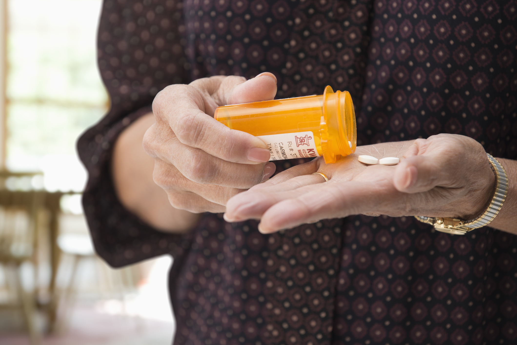 Woman holding medication pills.