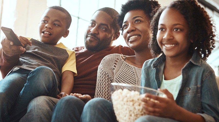 Family prepares to watch a movie and eat popcorn together.