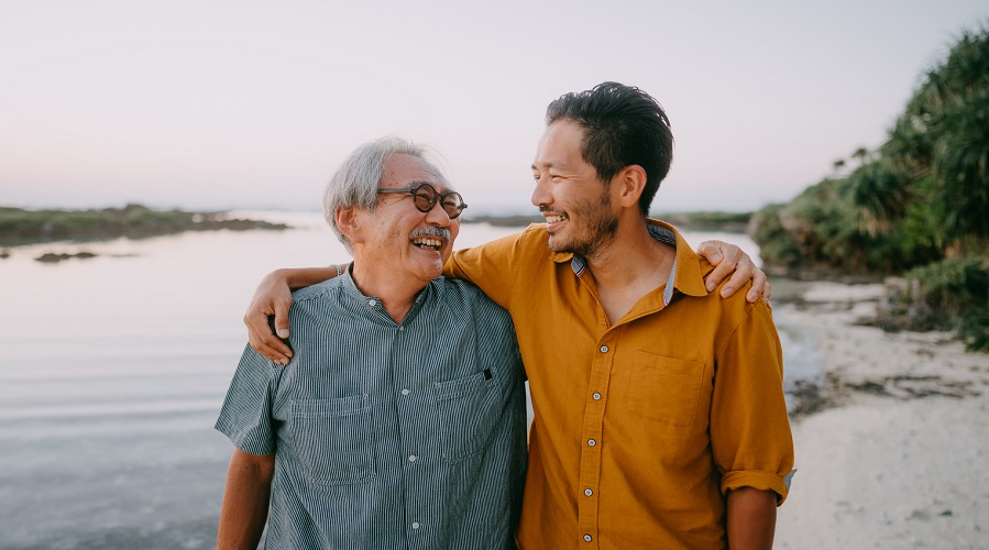 Senior father and adult son having a good time on beach at sunset, Kikai Island of the Amami Islands, Kagoshima, Japan