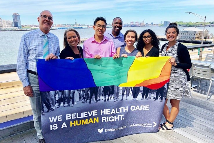 Prism leaders and allies displaying our 2019 Pride banner at Water Street