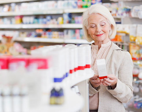 Senior woman reading package in drug store