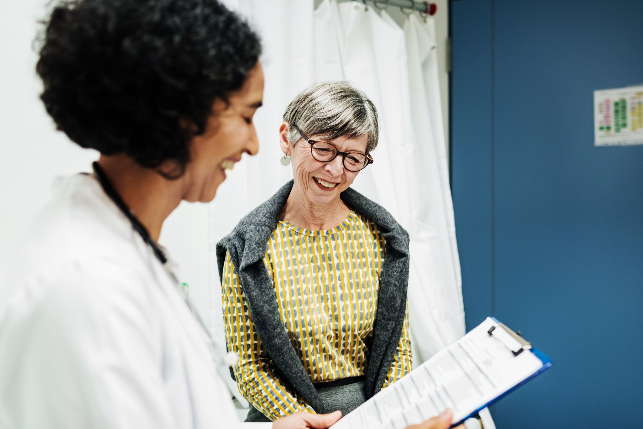 A clinical doctor going over some test results with an elderly patient at the hospital.