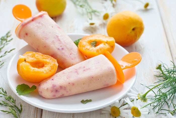 Two popsicles on a place with peaches.