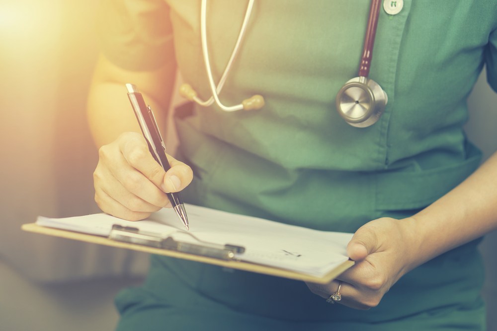 Nurse writing on clipboard.