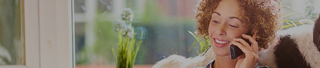 Woman on phone next to window.