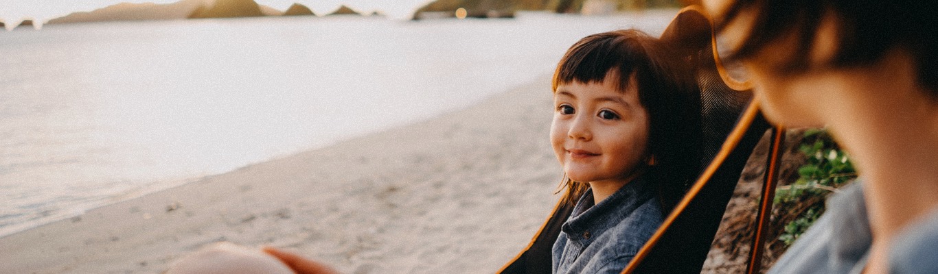 Young girl sitting in chair at the beach.