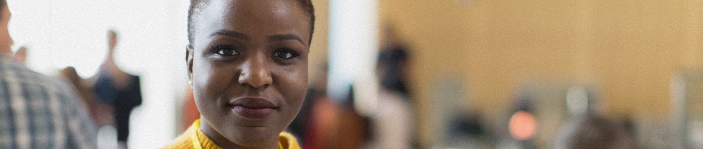 Woman in yellow smiling at the camera.