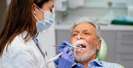 Man is getting procedure with his dentist