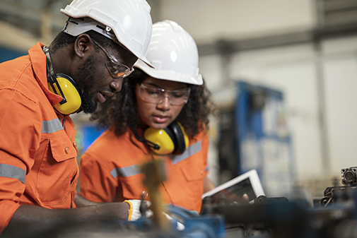 Boosting and Improving Manufacturing Process Efficiency in Welding Assembly Line. African American Manufacturing Process Engineers Team having discussion on welding jig assembly to tolerance variations in the product parts.