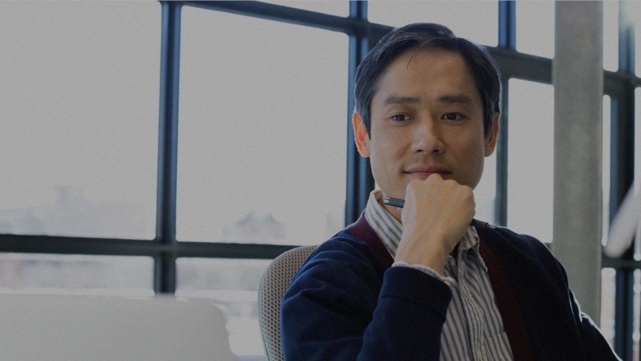 Man holding pen sitting in office.