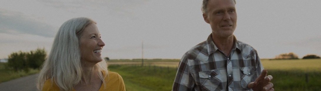 Senior couple walking outside near field.