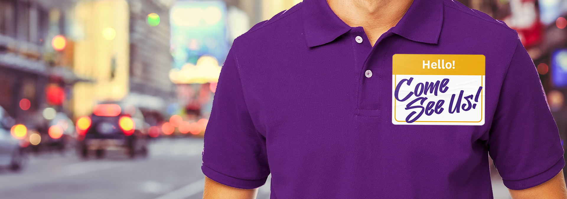 EmblemHealth community event coordinator wearing a purple shirt in an urban area.