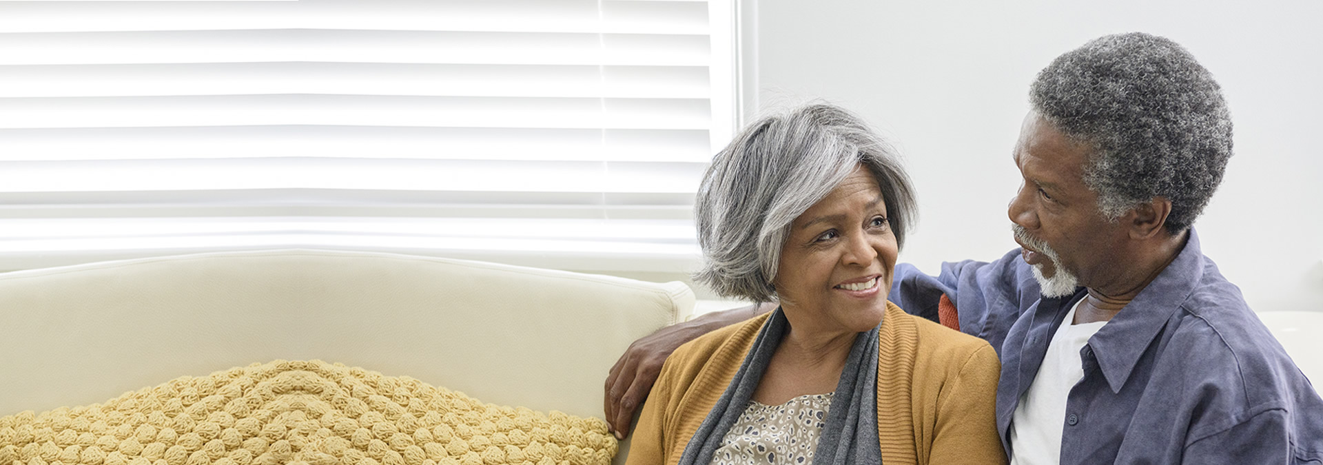 Senior couple sitting on couch talking