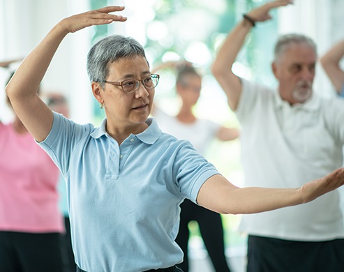 Asian woman attending indoor tai chi class