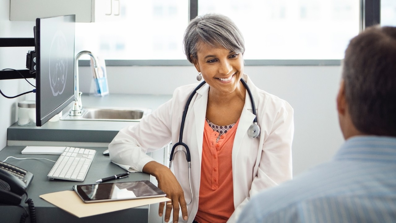 Health care provider speaking with patient in office