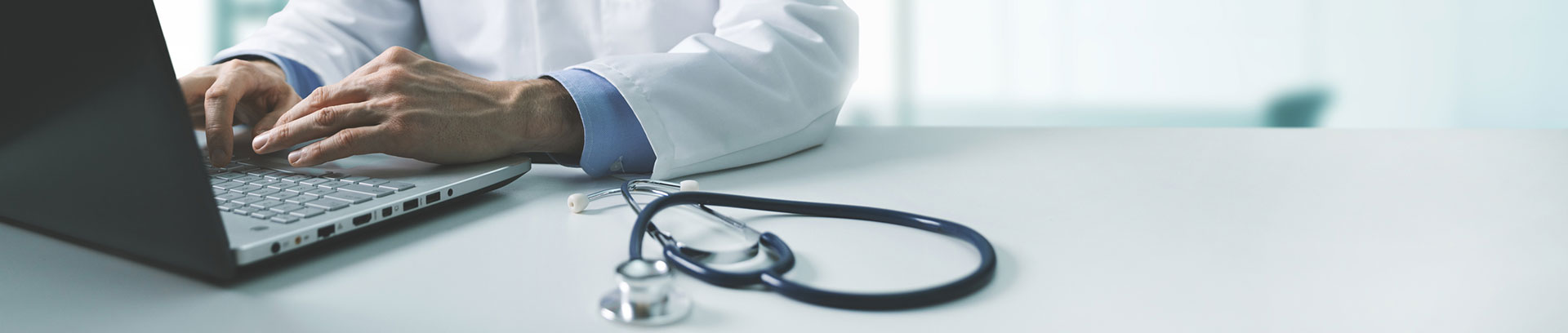 stethoscope next to provider using computer