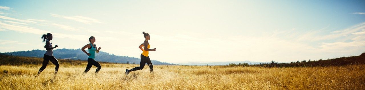 Three women jogging on sunny day