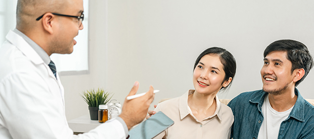 young happy pregnant couple at a doctor visit