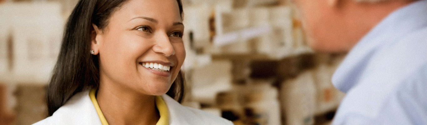 Pharmacist smiling at male customer.
