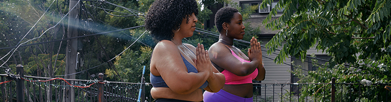 Two female adults doing yoga outside