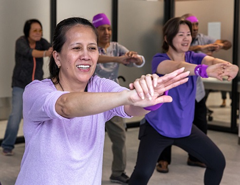 Men and women participate in a fitness class at a Neighborhood Care location.