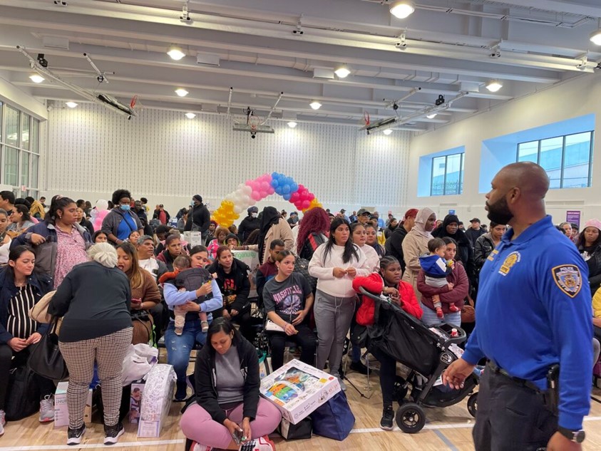 Expecting mothers receiving various gifts including diapers, onesies, tablets, car seats, and more at the NYPD community baby shower hosted in all five Burroughs sponsored by EmblemHealth