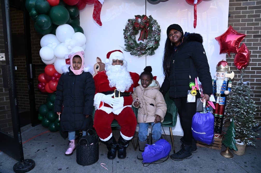 A family poses together with Santa at EmblemHealth Winter Wonderland.