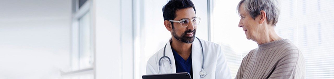 A male doctor discusses results with a senior female patient