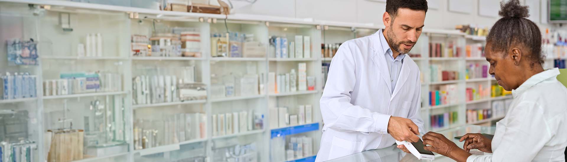 Senior woman talking to pharmacist at counter