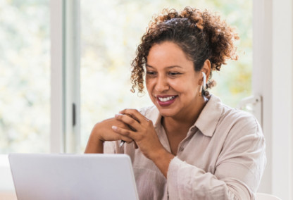 Young woman looking at a laptop and smiling