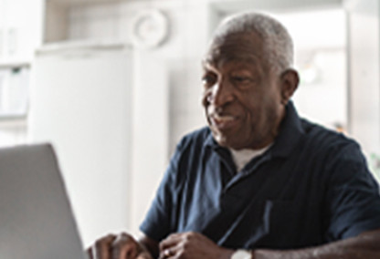 Older man on computer smiling