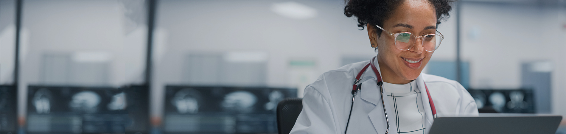 Female doctor on laptop and smiling