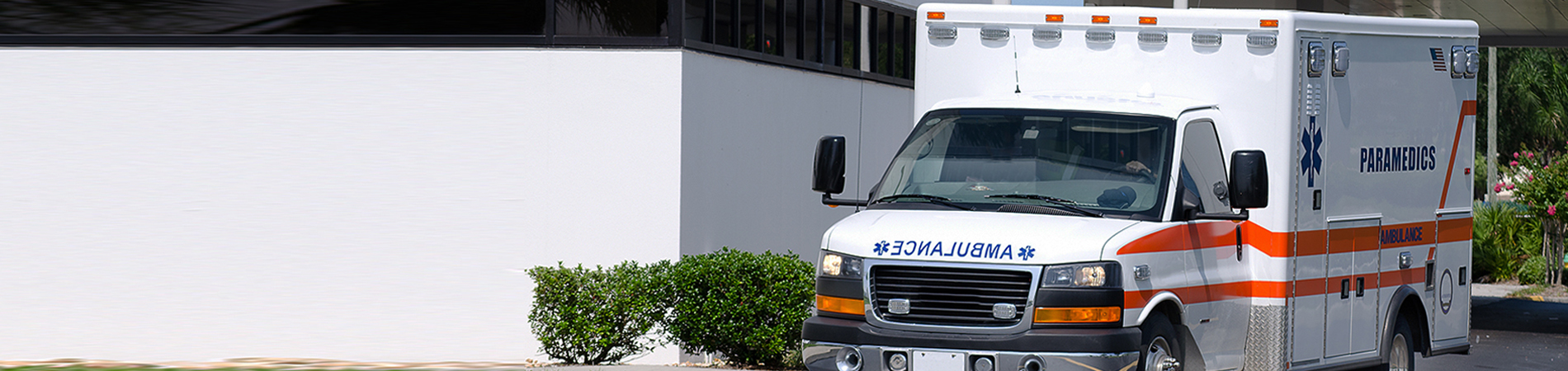 Ambulance driving away from a hospital emergency drop off area