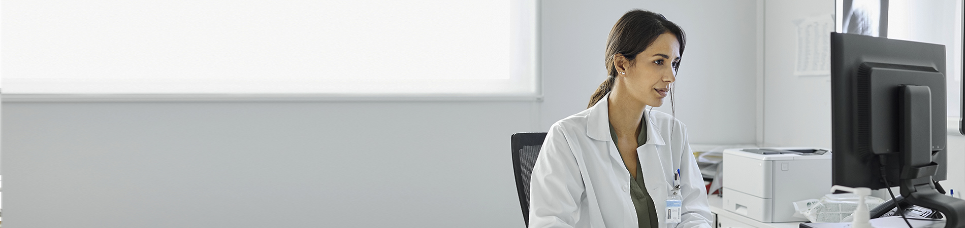 Female young doctor using computer at desk