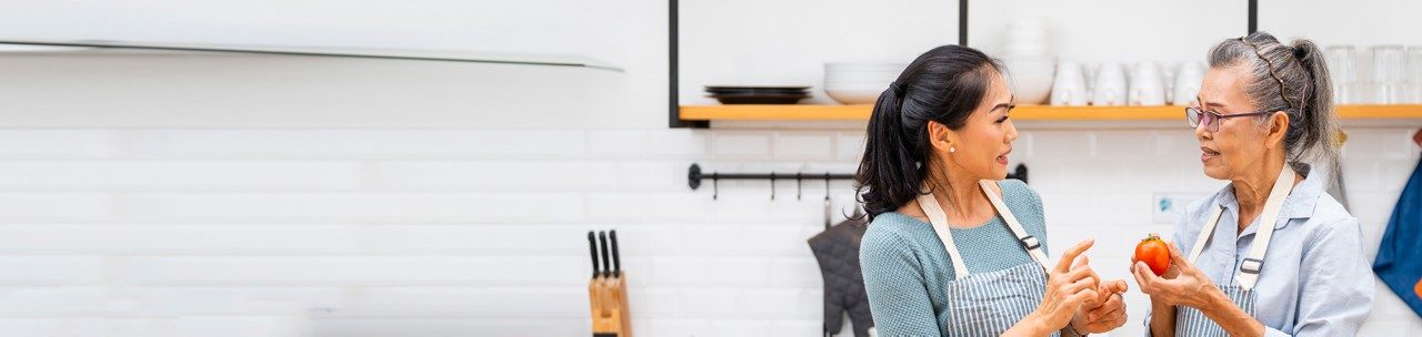 Asian woman providing tips about healthy eating to elderly woman