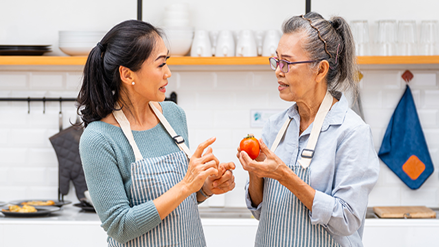 Asian family senior mother and daughter cooking salad in the kitchen at home