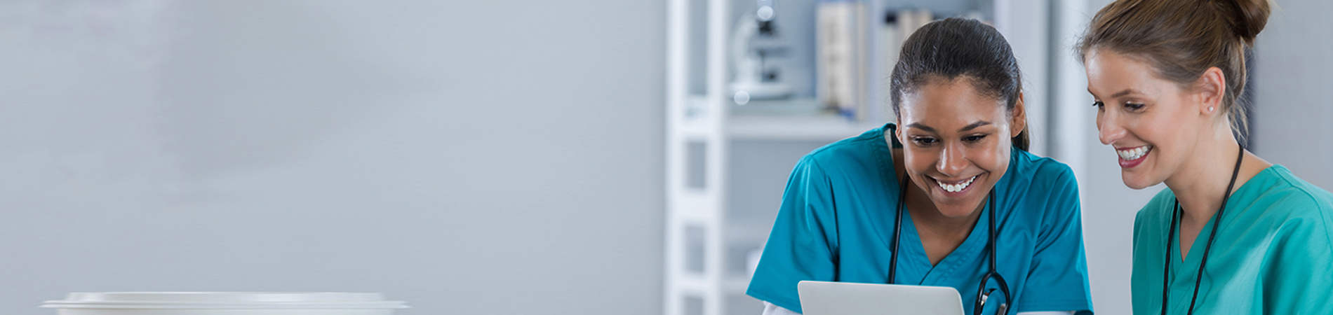 two healthcare providers smiling and looking at computer