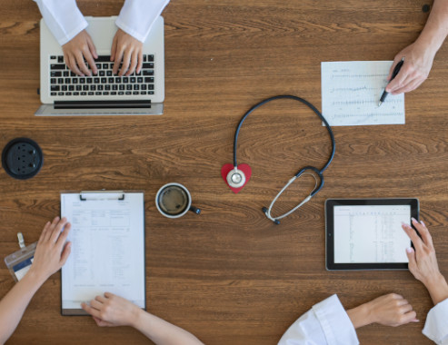 Four people at a desk reviewing documents