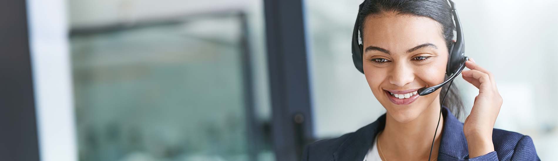 happy business person with headset at her computer