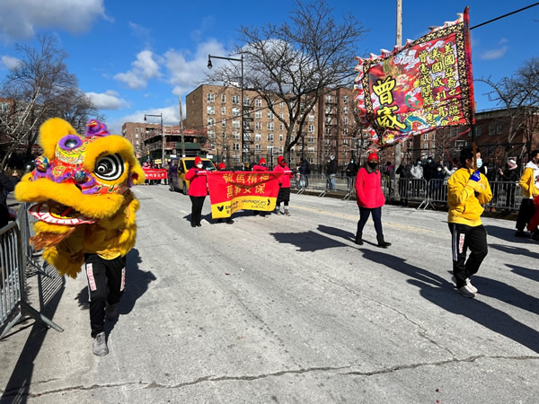 Lion Dancer and volunteers march down the parade route