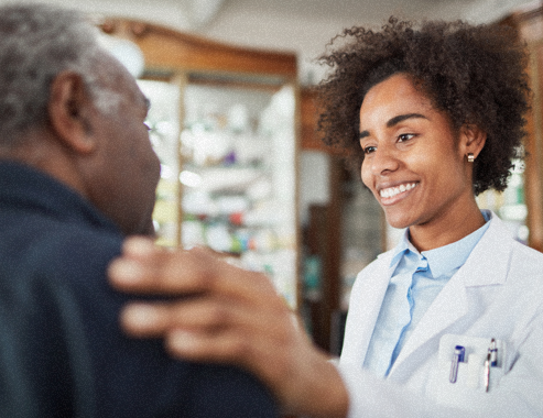 Female pharmacist smiling and putting hand on customer's shoulder.